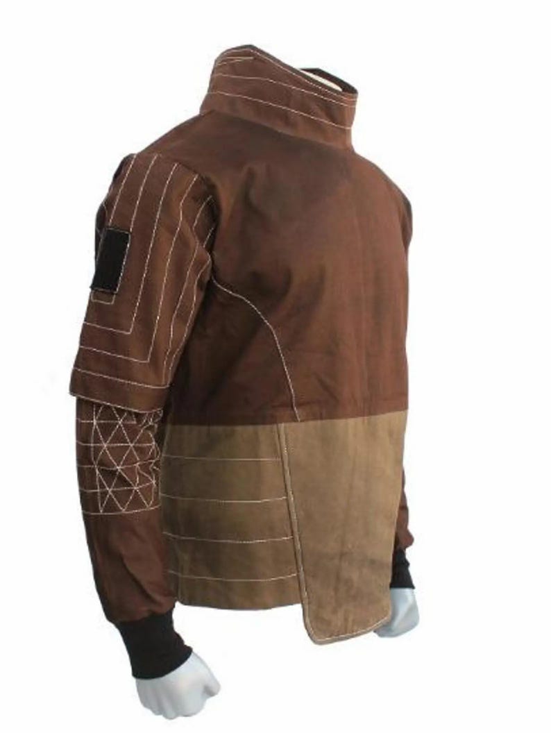 May include: Brown jacket with a high collar and contrasting panels. The jacket features white stitching details and a black patch on the upper sleeve. The lower portion of the jacket is a lighter brown color.