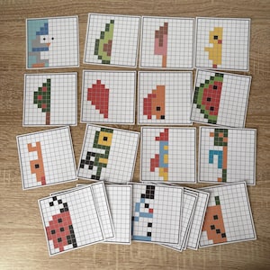 May include: A collection of pixel art cards featuring various images, including a snowman, avocado, ice cream, chick, Christmas tree, watermelon, and ladybug. Each card has a grid pattern and a partially completed image.