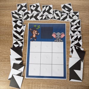 May include: A children's game with a blue and white game board, featuring a monkey and elephant illustration. The game includes black and white geometric pattern tiles. The game board has nine white squares for tile placement.