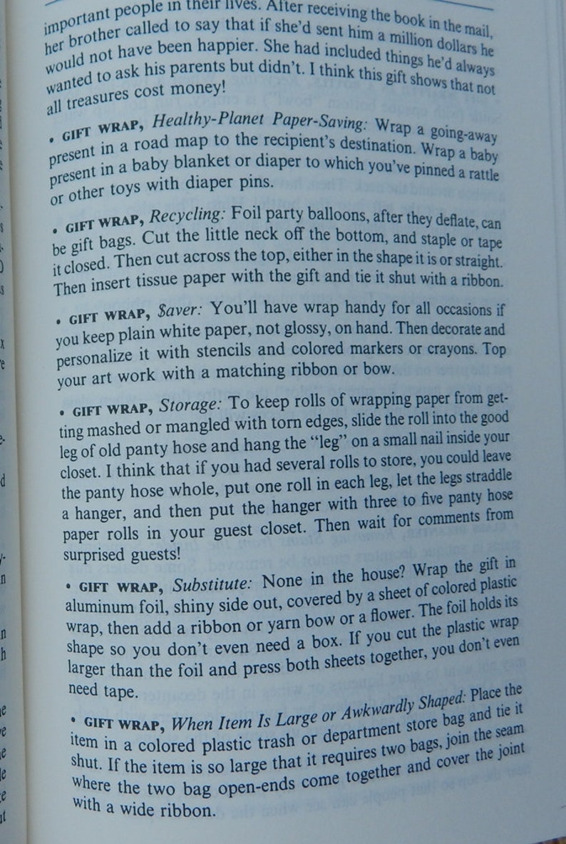 May include: Open book with text about gift wrapping ideas. The text includes tips for eco-friendly wrapping, recycling, and creative storage solutions. The page is from a book with a vintage aesthetic.