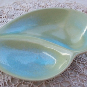 May include: A light green and blue divided serving dish with a unique, organic shape. The dish has a glossy finish and is perfect for serving snacks or appetizers.