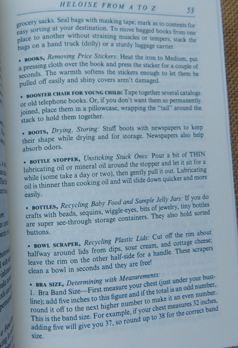 May include: Open book page with text. The title "HELOISE FROM A TO Z" is at the top. The text provides tips on topics like removing price stickers from books, drying boots, and recycling baby food jars. The page number is 53.