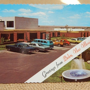 May include: A vintage postcard with a blue sky and white clouds. The postcard shows a building with a fountain in front of it. The text on the postcard reads "Greetings from Belen, New Mexico".
