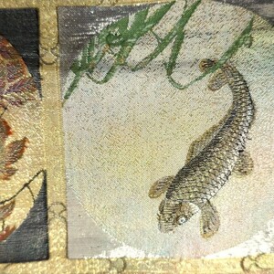 Pu&ograve; includere: Un primo piano di un tessuto giapponese tradizionale con sfondo dorato e argentato. Il tessuto presenta un motivo ripetitivo di vari motivi floreali e animali, tra cui un drago, una fenice e un pesce. Il tessuto &egrave; tessuto con dettagli intricati ed &egrave; un bellissimo esempio dell'artigianato giapponese.