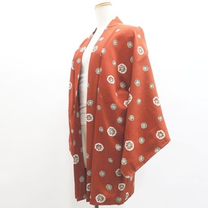 May include: A red and white patterned Japanese kimono with a floral design. The kimono is made of a soft, lightweight fabric and is perfect for layering.