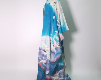 Può includere: Un kimono blu e bianco con un motivo di gru bianche che volano su un cielo blu e rosa. Il kimono è in seta e presenta un design giapponese tradizionale.