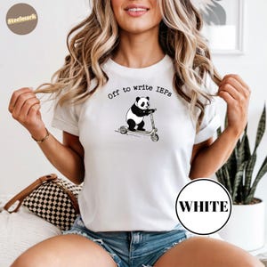 Peut inclure: T-shirt blanc avec un panda sur un scooter et le texte "Off to write IEPs". Le panda est noir et blanc, le scooter est gris. Un cercle blanc est visible sur le t-shirt.
