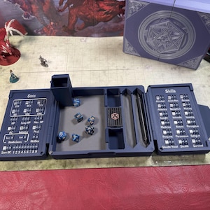 Pu&ograve; includere: Un organizzatore pieghevole per giochi da tavolo di colore blu scuro, dotato di un vassoio centrale per il lancio dei dadi, una torre per dadi e due pannelli laterali con quadranti meccanici integrati per monitorare statistiche e abilit&agrave;.