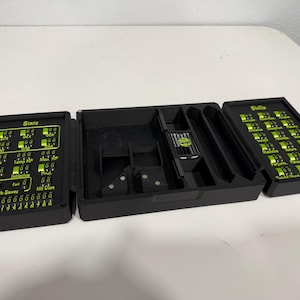 Pu&ograve; includere: Un organizzatore da tavolo nero pieghevole in tre parti con accenti e testo verde brillante. Il pannello sinistro mostra "Stats" con quadranti regolabili, la sezione centrale ha scomparti e il pannello destro elenca "Skills" con quadranti.