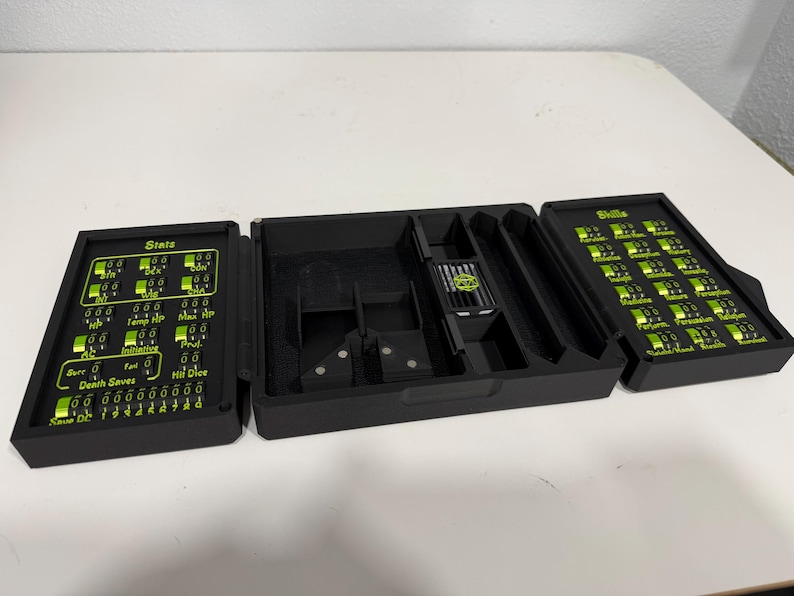 Pu&ograve; includere: Un organizzatore da tavolo nero pieghevole in tre parti con accenti e testo verde brillante. Il pannello sinistro mostra "Stats" con quadranti regolabili, la sezione centrale ha scomparti e il pannello destro elenca "Skills" con quadranti.
