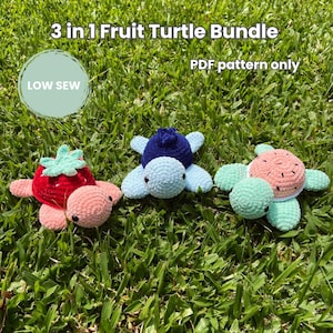 May include: Three crocheted turtle toys featuring fruit-themed shells. One has a red strawberry shell, one a dark blue blueberry shell, and one a pink watermelon shell. Text reads 3 in 1 Fruit Turtle Bundle, PDF pattern only, and LOW SEW.