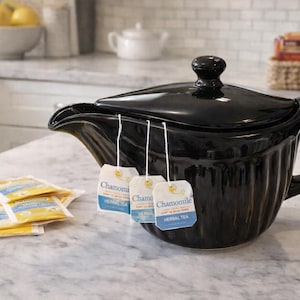 Może przedstawiać: Zestaw trzech ceramicznych kubków z nakrapianym, matowym wykończeniem. Kubki są w odcieniach kremowym, jasnoszarym i ciemnoszarym. Każdy kubek ma prosty, minimalistyczny design, idealny do kawy lub herbaty.