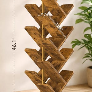 Puede incluir: Una estanter&iacute;a de madera con un dise&ntilde;o &uacute;nico en forma de &aacute;rbol. La estanter&iacute;a mide 117 cm de alto, 30 cm de ancho y 17 cm de profundidad. Cuenta con m&uacute;ltiples estantes para exhibir libros o art&iacute;culos decorativos. La madera tiene un acabado marr&oacute;n c&aacute;lido.