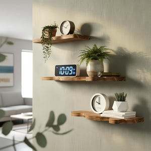 May include: Three wooden floating shelves with various decorative items. The top shelf holds a round clock and a potted plant. The middle shelf displays a digital clock showing 10:09 and a potted plant. The bottom shelf has a white clock and a small succulent.