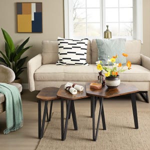 May include: A set of three nesting tables with dark brown wood-grain tops and black metal legs. The tables are arranged in a staggered formation, featuring a triangular shape with rounded corners, providing a functional surface for home decor.