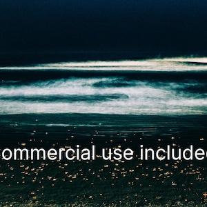 May include: An abstract seascape with a dark blue sky and ocean. White foamy waves roll across the water. The text "Commercial use included" is written across the bottom of the image. The bottom of the image has small yellow lights.