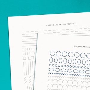 Puede incluir: Dos hojas de papel con el texto "Strokes and Shapes Practice" en la parte superior. La hoja superior tiene una variedad de líneas y formas grises. La hoja inferior tiene una variedad de círculos y óvalos azules, y arcos grises.