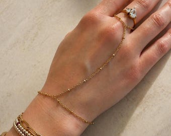 Cadena de mano con cuentas. Bañada en oro de 18 quilates.