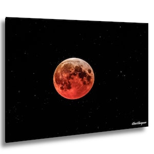 May include: A striking image of a blood moon set against a black, star-filled sky. The moon is a vivid red-orange, with visible craters and textures. The artist's signature, Chris Thompson, is in the lower right corner.