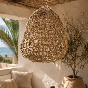 Boho chic braided mesh pendant light, perfect for indoor or outdoor use. Trendy boho chic crocheted and macrame lamp made from natural fibers.