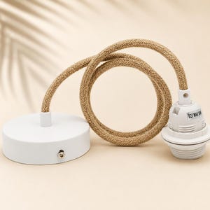Op de afbeelding: Een witte plafondkap verbonden met een witte E27-fitting via een beige gevlochten stoffen snoer. De fitting is voorzien van een label met de tekst E27 MAX 60W. Het geheel bevat een ronde witte basis met een kleine schroef aan de zijkant.