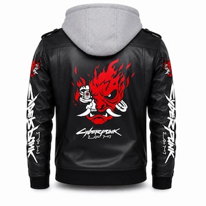 May include: A black faux leather jacket with a grey hood, featuring a large red and white graphic of a stylized robotic demon face on the back. The text Cyberpunk 2077 is printed below the graphic, and the sleeves feature white Cyberpunk 2077 text.