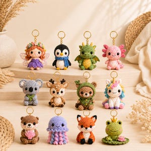 Può includere: Una collezione di dodici portachiavi all'uncinetto raffiguranti vari personaggi tra cui una fata, un pinguino, un drago, un axolotl, un koala, un cervo, un orso, un unicorno, una lontra, una medusa, una volpe e una rana su una ninfea.