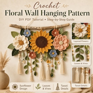 May include: A crochet floral wall hanging pattern featuring a large central sunflower, layered flowers in cream, pink, and blue, green leaves, and vines. The design includes wooden beads and cream-colored tassels suspended from a natural wooden branch.