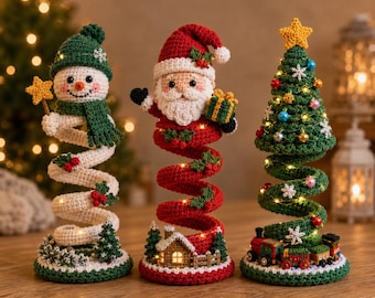May include: Three crocheted holiday figures featuring a snowman in a green hat, Santa Claus holding a gift, and a decorated Christmas tree with a train. Each figure has a spiral base, integrated warm string lights, and festive details.