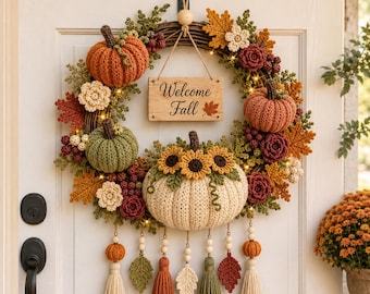 May include: A circular wreath featuring crocheted pumpkins in orange, green, and cream, accented with crocheted flowers, leaves, and berries. A wooden sign hangs in the center with the text Welcome Fall. Tassels and beads hang from the bottom.