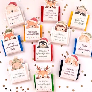May include: Ten rectangular chocolate bars wrapped in white paper with colorful edges, each topped with a die-cut illustration of a festive animal wearing a winter hat and German holiday greetings printed on the front.