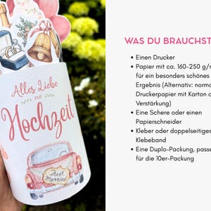 May include: A cylindrical paper wrapper featuring the German text Alles Liebe zur Hochzeit and a pink car with a Just Married sign. The top displays watercolor illustrations of wedding rings in a blue box, gold bells, and pink hearts.