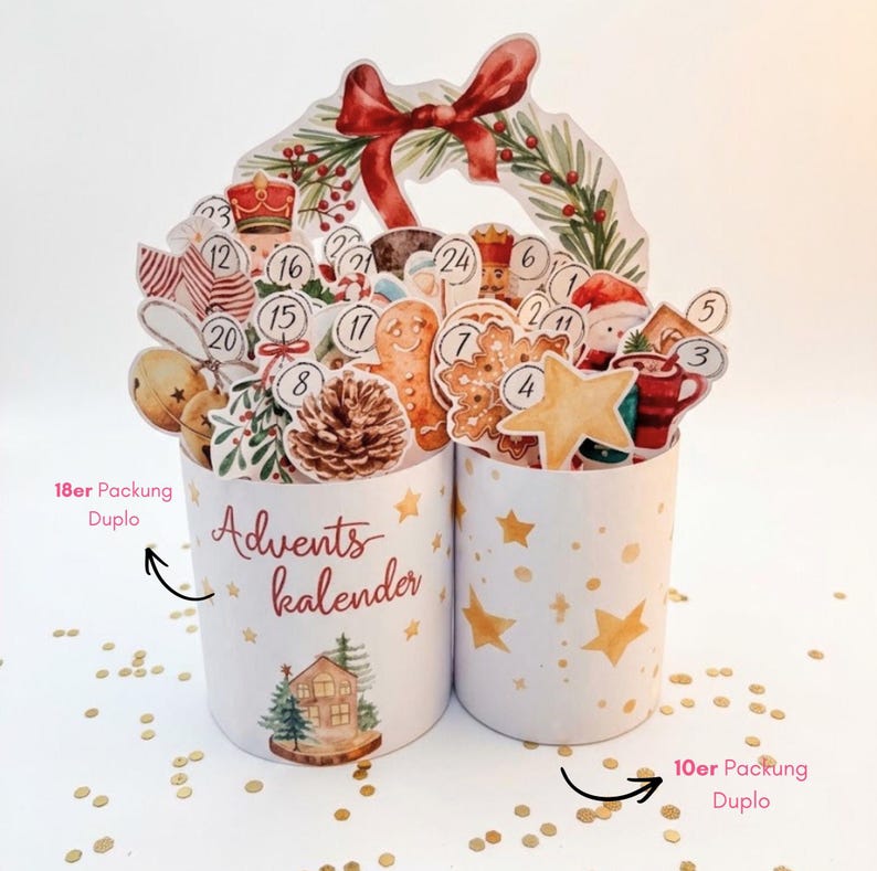 May include: A two-part cylindrical advent calendar featuring festive watercolor illustrations of a nutcracker, gingerbread man, pinecone, and star. The left cylinder displays the text Advents kalender, 18er Packung Duplo, and 10er Packung Duplo.