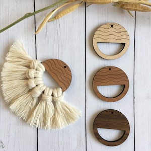 May include: Four wooden circles with a wavy pattern and a cut-out shape. The circles are in various shades of brown and are arranged vertically on a white wooden background.