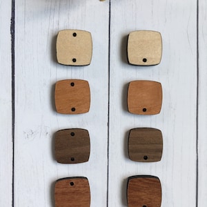 May include: Eight wooden square shapes with two holes in each. The squares are in four different wood tones: light brown, medium brown, dark brown, and reddish brown.
