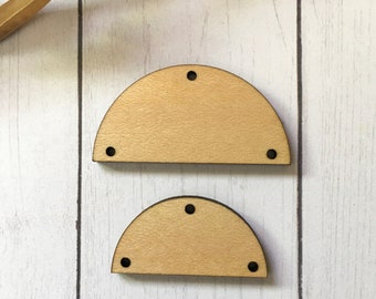 May include: Two unfinished wooden half-circle shapes with holes drilled around the edges. The larger shape is about 3 inches wide and the smaller shape is about 2 inches wide.