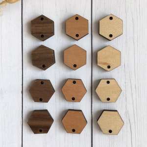 May include: Twelve wooden hexagon shapes, three rows of four. The top row is dark brown, the middle row is light brown, and the bottom row is a medium brown. Each hexagon has two holes.