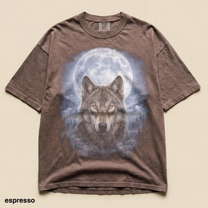 May include: Espresso-colored t-shirt featuring a detailed wolf illustration set against a full moon backdrop. The wolf has piercing yellow eyes. The shirt's design includes a forest scene. The word "espresso" is printed at the bottom.