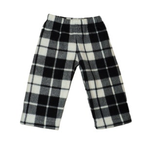 Black and white plaid pants with legs apart. Straight legs that are hemmed at the bottom. Narrow black and white lines separating black, gray and white squares. Elastic waistband.