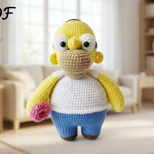 May include: A crocheted Homer Simpson doll, with a yellow head, arms, and ears, a white shirt, blue trousers, and brown shoes. The doll holds a pink donut. The image has the text "PDF" in the upper left corner.