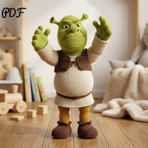 Può includere: Bambola all'uncinetto di Shrek, il personaggio orco. La bambola è principalmente verde, con una camicia beige, un gilet marrone e scarpe marroni. Le braccia della bambola sono alzate. La parola "PDF" è visibile.