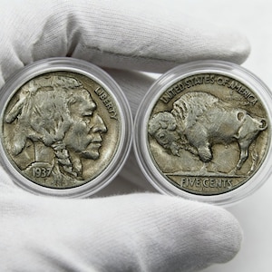 May include: Two silver Buffalo nickels in protective cases. One coin features a Native American profile and the year 1937. The other coin shows a bison and the words "Five Cents."