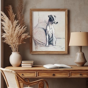 May include: A framed black and white illustration of a dog sitting on a chair. The illustration is hanging on a wall with a wooden desk and a wicker chair in front of it. A lamp is on the desk with a stack of books.