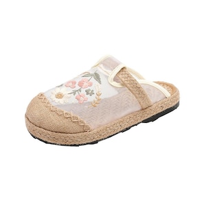 May include: A beige sandal with a woven jute sole and floral embroidery. The sandal has a mesh upper and a braided strap. The sole is black, and the design is casual. The sandal is suitable for warm weather.