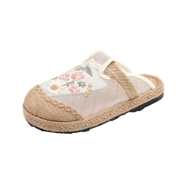May include: A beige sandal with a woven jute sole and floral embroidery. The sandal has a mesh upper and a braided strap. The sole is black, and the design is casual. The sandal is suitable for warm weather.