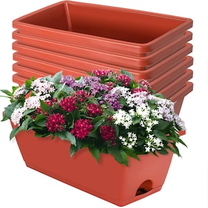 May include: A stack of rectangular, terracotta-colored planters with a vibrant display of flowering plants. The flowers are a mix of red, white, and purple, with green foliage. The planters are made of a durable plastic material.