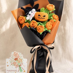 May include: A crochet bouquet featuring orange flowers, a green-leafed jack-o'-lantern, and a small white ghost wearing a black hat. The arrangement is wrapped in black and orange paper, tied with black and beige ribbons, and includes a card with the text Happy Every day.