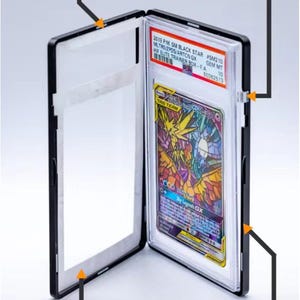 May include: Black card holder with a magnetic closure and sliding lock. The holder contains a colorful trading card with the text "TAG TEAM GX". The holder also has an artwork insert and metal components.
