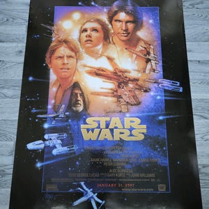 May include: Special Edition Star Wars film poster featuring Luke Skywalker, Princess Leia, and Han Solo. The poster has a dark blue background with images of X-wing fighters and the Star Wars logo. The text "January 31, 1997" is also visible.
