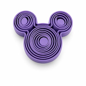Puede incluir: Un juego de cortadores de galletas de pl&aacute;stico morado con forma de silueta de cabeza de rat&oacute;n. El dise&ntilde;o presenta un marco circular central grande con dos marcos circulares m&aacute;s peque&ntilde;os en la parte superior, cada uno con varios cortadores de anillos conc&eacute;ntricos.